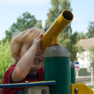 Boy looking through toy telescope